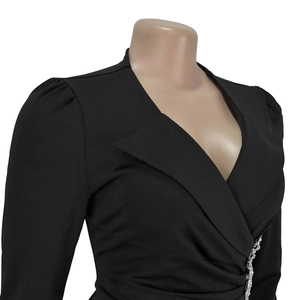 Dettaglio di un vestito nero con scollo a V e decorazione in strass argentati