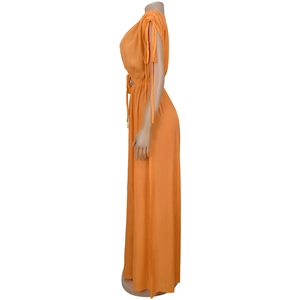 Close-up of drawstring cuff detail and waist tie on this orange V-neck maxi jumpsuit