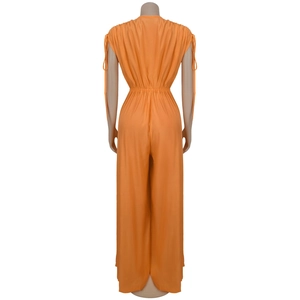 Detail view of orange sleeveless jumpsuit back featuring V-neck and drawstring shoulders