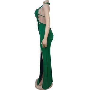 Detail view of emerald green knit halter dress featuring waist cutout and high side slit