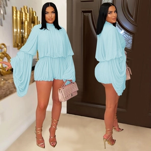 Sky blue pleated romper with high neck and wide sleeves shown in a front and side view