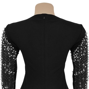 Detail of elegant black dress showing intricate pearls and rhinestones on the sleeves