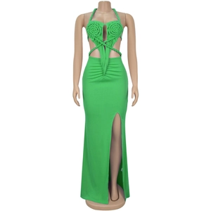 Detail of green halter dress featuring knit flowers and crisscross waist cut-outs