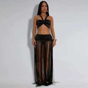 Detailansicht des schwarzen Halter-Tops und Fransenrocks-Sets mit elegantem Satinglanz