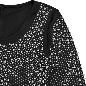 Detailed view of elegant faux pearls and shimmering rhinestones on black evening dress