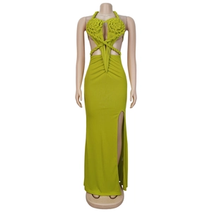 Detail of green halter neck knit dress with 3D floral accent and high side slit
