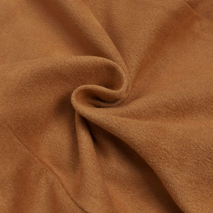 Texture macro du tissu suédine camel doux avec plis en spirale et fini velours délicat