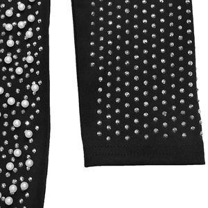 Detail of black knit fabric with elegant white pearls and silver rhinestones embroidery