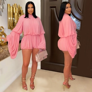 Detailed view of pink pleated long-sleeve romper with elastic waist and lantern sleeves