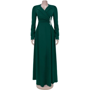 Dettaglio delle pieghe in vita e strass argentati sul vestito lungo verde scuro