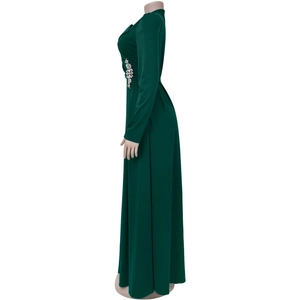 Dettaglio dell'abito lungo verde scuro con decorazione floreale in strass argentati in vita