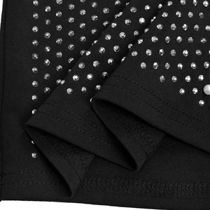 Close-up of black dress fabric with sparkling rhinestones, pearl accents and fine stitching
