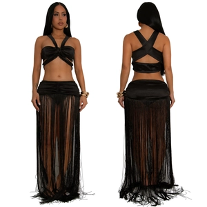 Detail eines schwarzen Zweiteilers mit Neckholder-Top und langem Fransenrock