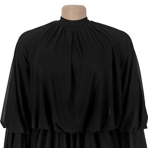 Detail of sheer black pleated turtleneck mesh top with elegant puff sleeves texture