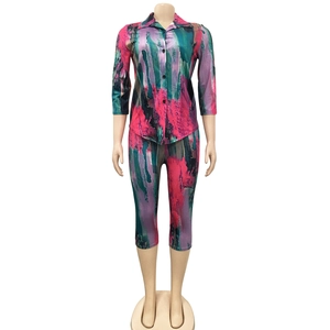Detail of colorful abstract print shirt with buttons and matching high-waisted trousers
