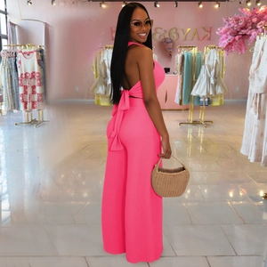Close-up of bright pink ribbed knit fabric with halter neck bow tie back detail