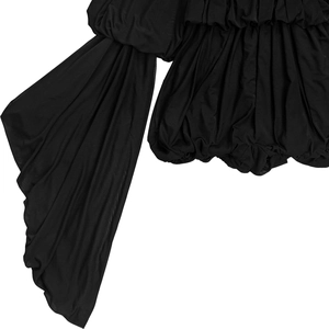Close-up of black pleated fabric detail with artistic layering on the fashion bodysuit