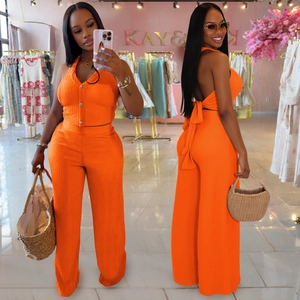 Detail of orange ribbed knit two-piece set featuring a halter top and wide-leg trousers