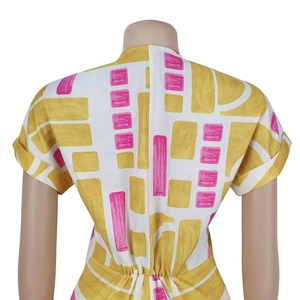 Detail view of the back zipper and waist pleats on this printed short sleeve jumpsuit