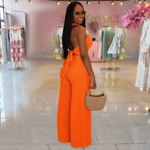 Detail of orange ribbed knit set featuring halter tie-back top and high-waist wide-leg pants