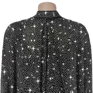 Gros plan détaillé de strass argentés multiformes sur tissu noir transparent de robe