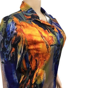Detail of artistic abstract print and black buttons on a women's V-neck shirt