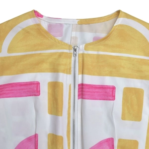 Close-up of summer jumpsuit with geometric yellow print and front metallic zipper