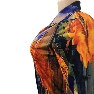 Detail view of abstract art print on a V-neck shirt with orange and blue oil painting style