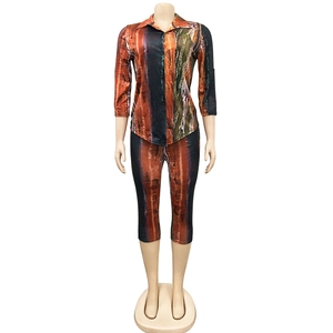 Detail of V-neck short sleeve top and leggings set with orange and black tie-dye print