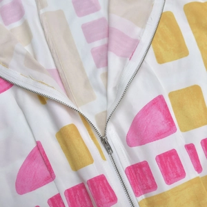 Macro view of colorful geometric print and silver metal zipper detail on jumpsuit
