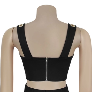 Detailansicht eines schwarzen Crop-Tops mit silbernem Reißverschluss und Goldösen
