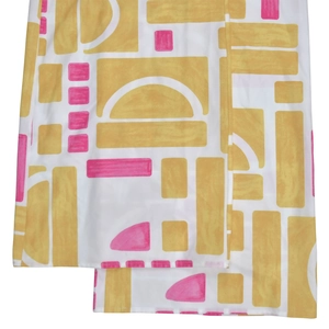 Macro view of geometric pattern print on summer jumpsuit fabric with yellow and pink shapes