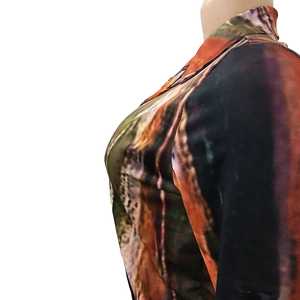 Detail shot of the abstract digital print pattern on women's V-neck top in orange and brown