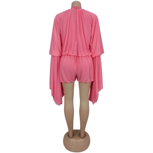 Rear view of pink pleated romper featuring dramatic oversized long flared sleeves and back zip