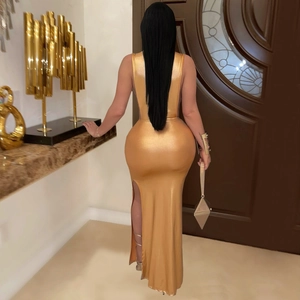 Close-up of elegant metallic gold backless dress with a high side slit and matching clutch