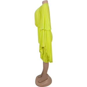 Detail view of neon yellow pleated romper showing draped sleeves and ruffle hem texture