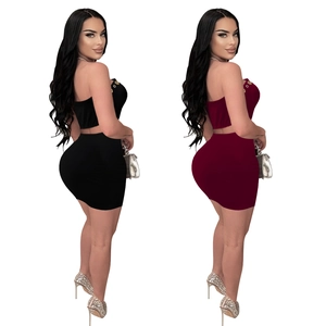 Detail of crop top and mini skirt set with golden ring accents in black and burgundy