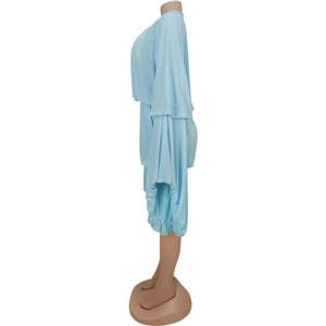 Detail view of light blue knitted set featuring elegant pleated draping and layered wide sleeves