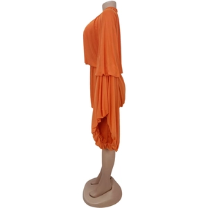 Detail of orange two-piece set featuring flared pleated sleeves and elastic fabric