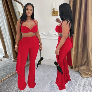 Détail d'un ensemble rouge deux pièces avec haut bandeau torsadé et pantalon évasé taille haute