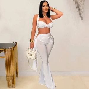 Détail du haut dos nu à nœud blanc et pantalon taille haute avec découpes latérales