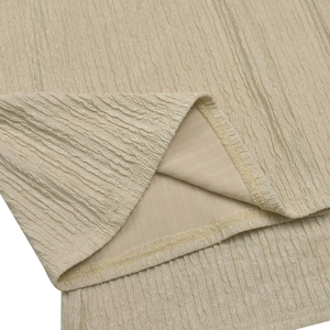 Detailed close-up of champagne pleated fabric and fine edge stitching on woman set