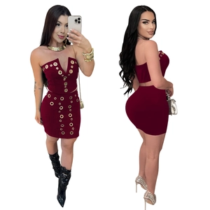 Detail of burgundy two-piece set featuring tube top and mini skirt with gold eyelet decor