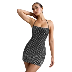 Detailed close-up of sparkling silver square sequins on a black halter neck mini dress