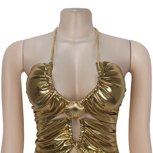 Nahaufnahme des goldfarbenen Neckholder-Tops mit Metallkette und Muschel-Schnallendetail