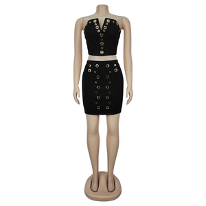 Detail of black bandeau top and mini skirt set featuring gold metal grommet hardware