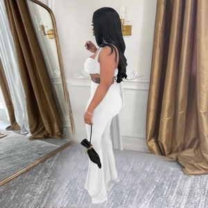 Vue latérale d'un ensemble blanc deux pièces avec crop top et pantalon évasé en studio