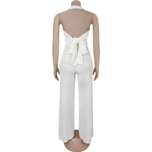 Detailed back view of white halter jumpsuit featuring an open back and elegant ribbon bow