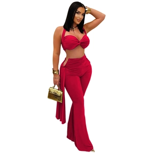 Détail du pantalon évasé rouge à taille haute avec découpe latérale et anneau en métal