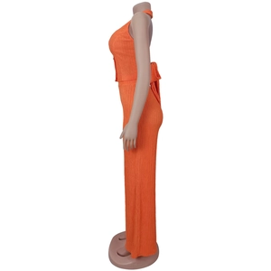 Detail of orange pleated two-piece set featuring halter neck top with large back bow